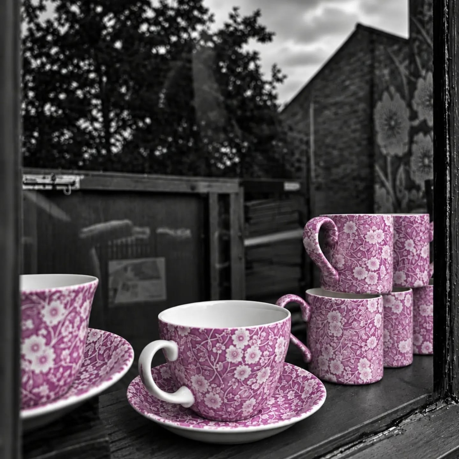 Pink patterned cups and ceramics displayed in a window at Middleport Pottery.