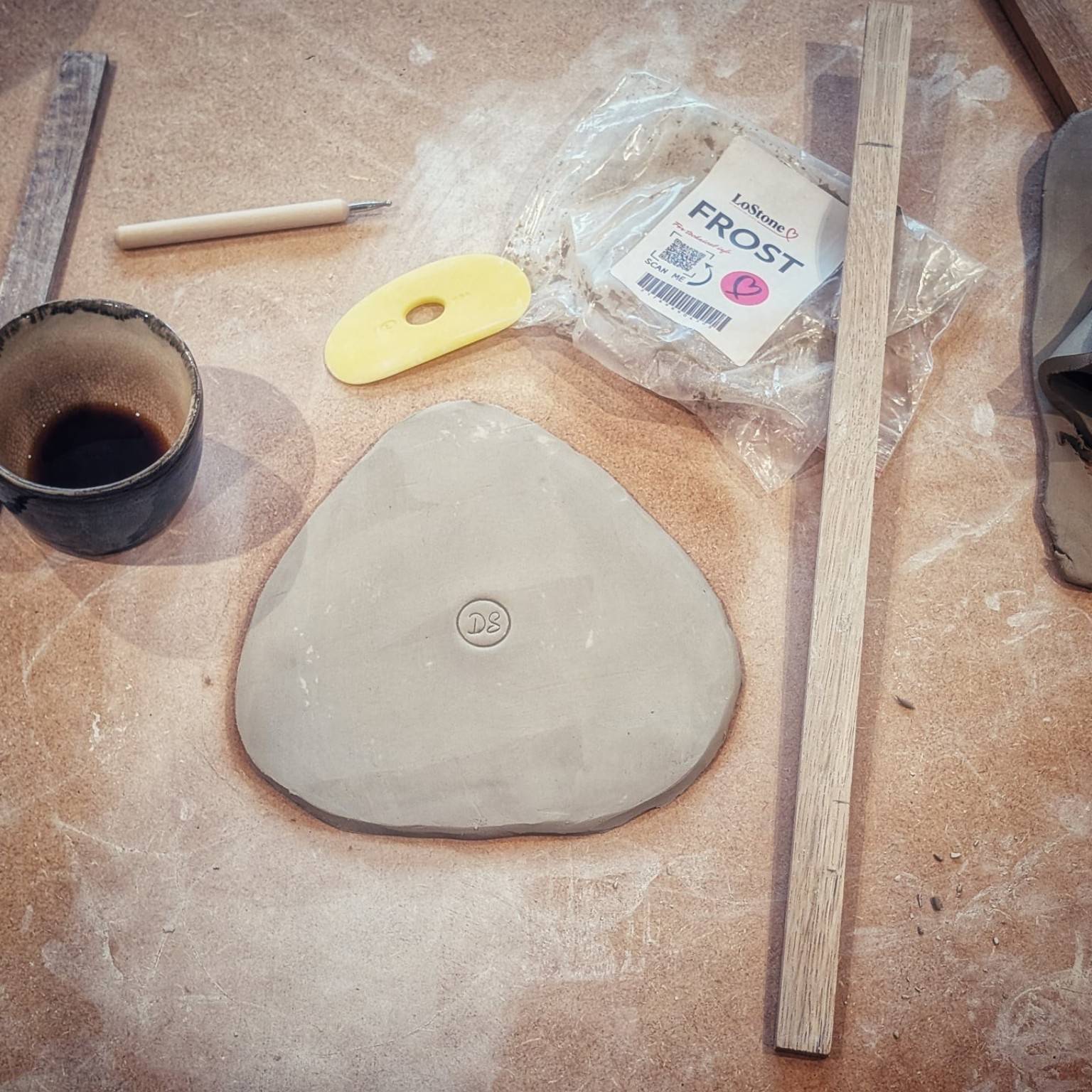 A hand-built triangular piece in LoStone Frost on the workbench