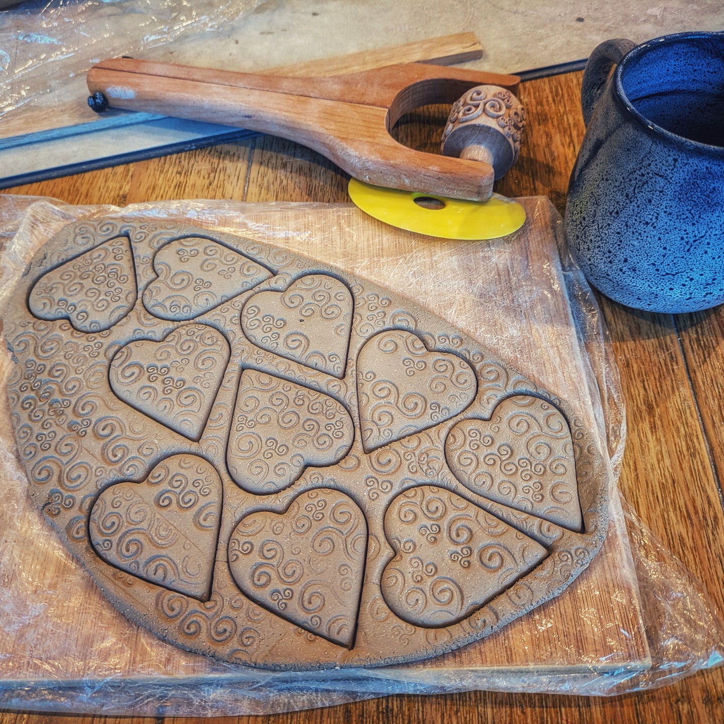 Hand-built clay forms being worked on the studio bench