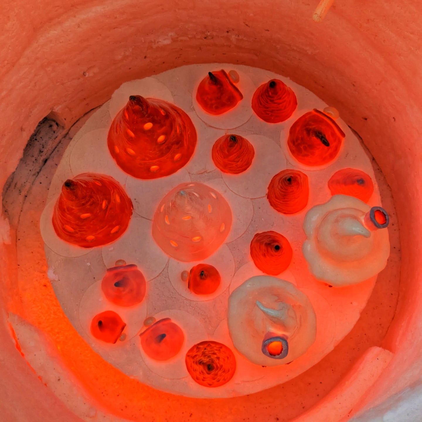 Ceramic pieces glowing orange inside the raku kiln