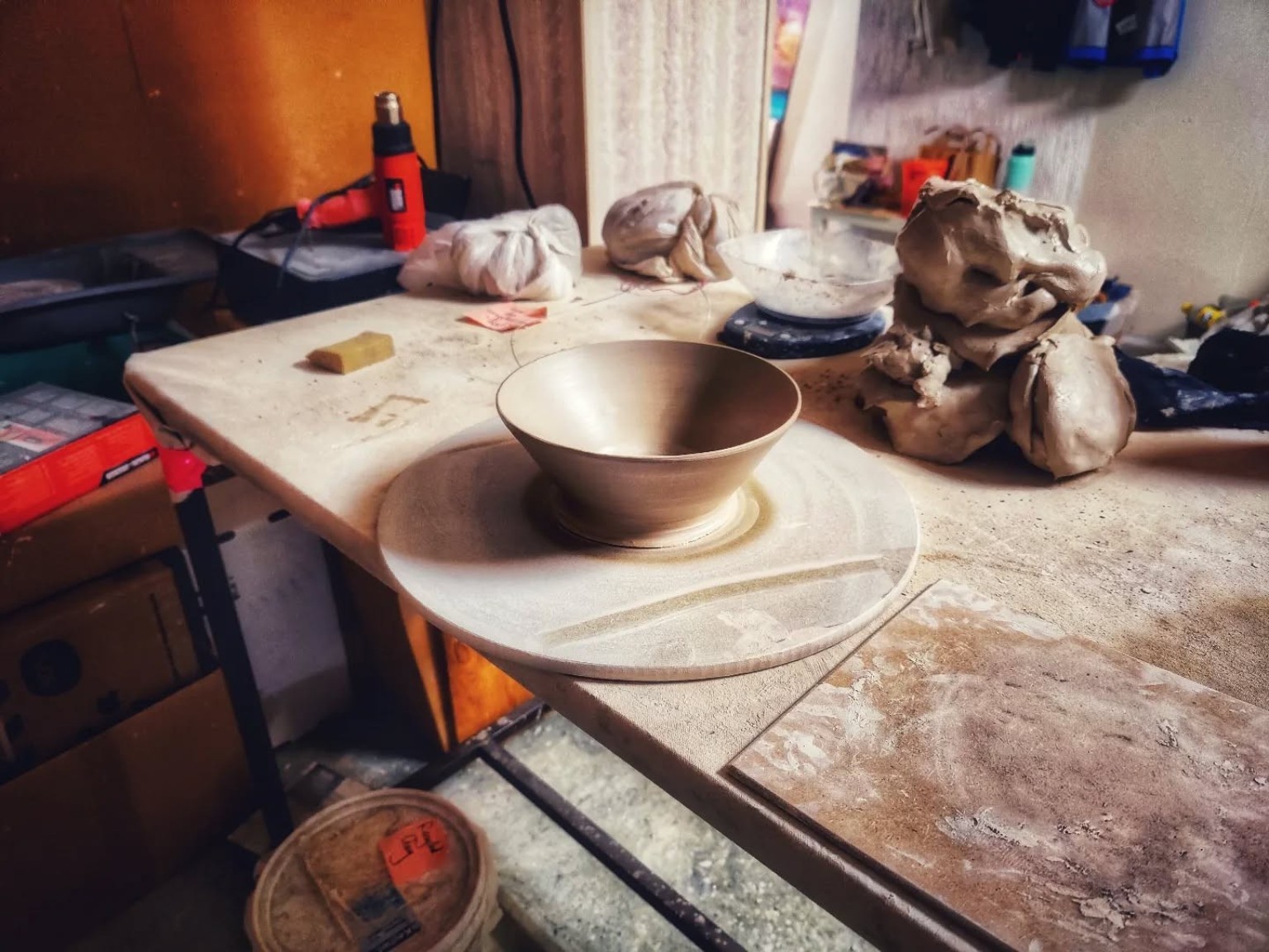 Wheel-thrown bowl on its bat at the studio workbench.