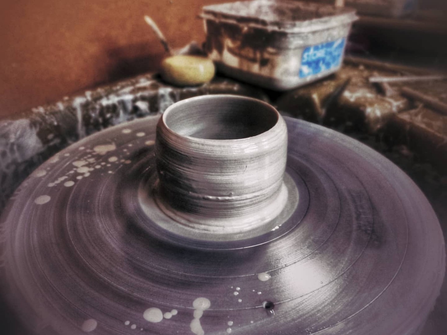 Close view of a freshly thrown studio cup on the pottery wheel.