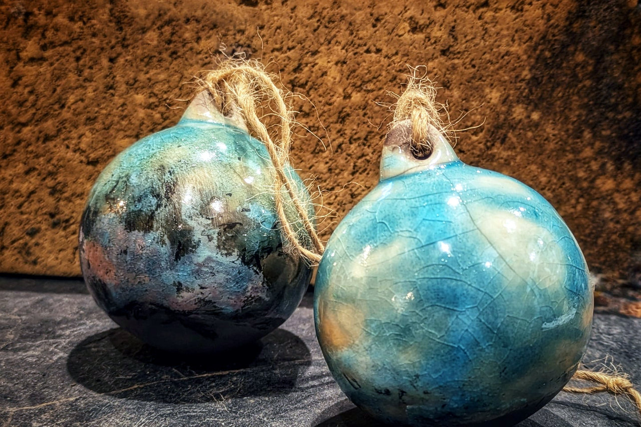Pair of blue-green raku Christmas tree baubles shown together, each with a rustic twine loop.