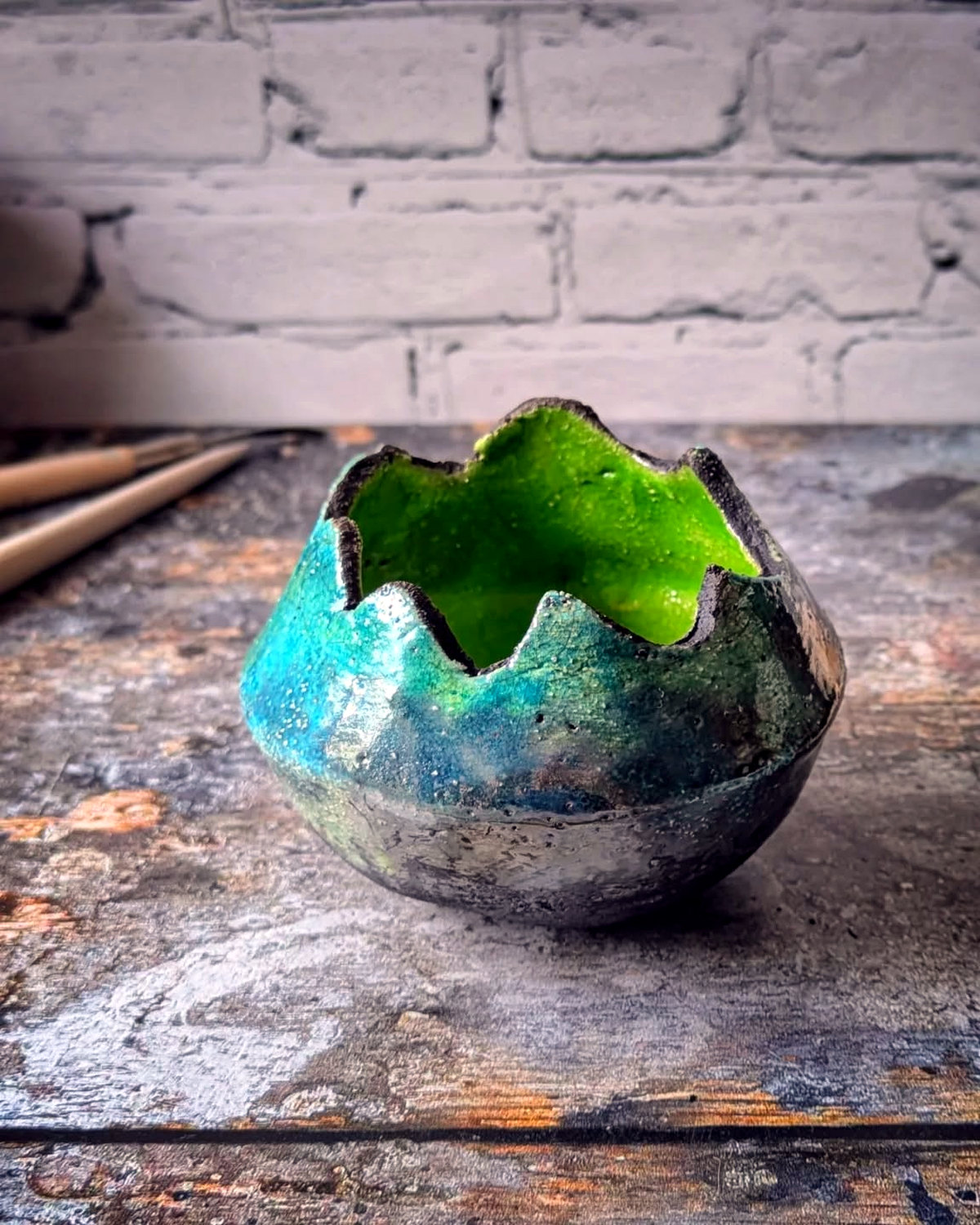 Sculptural vessel with an irregular rim, blue-green crackled exterior and vivid green interior.