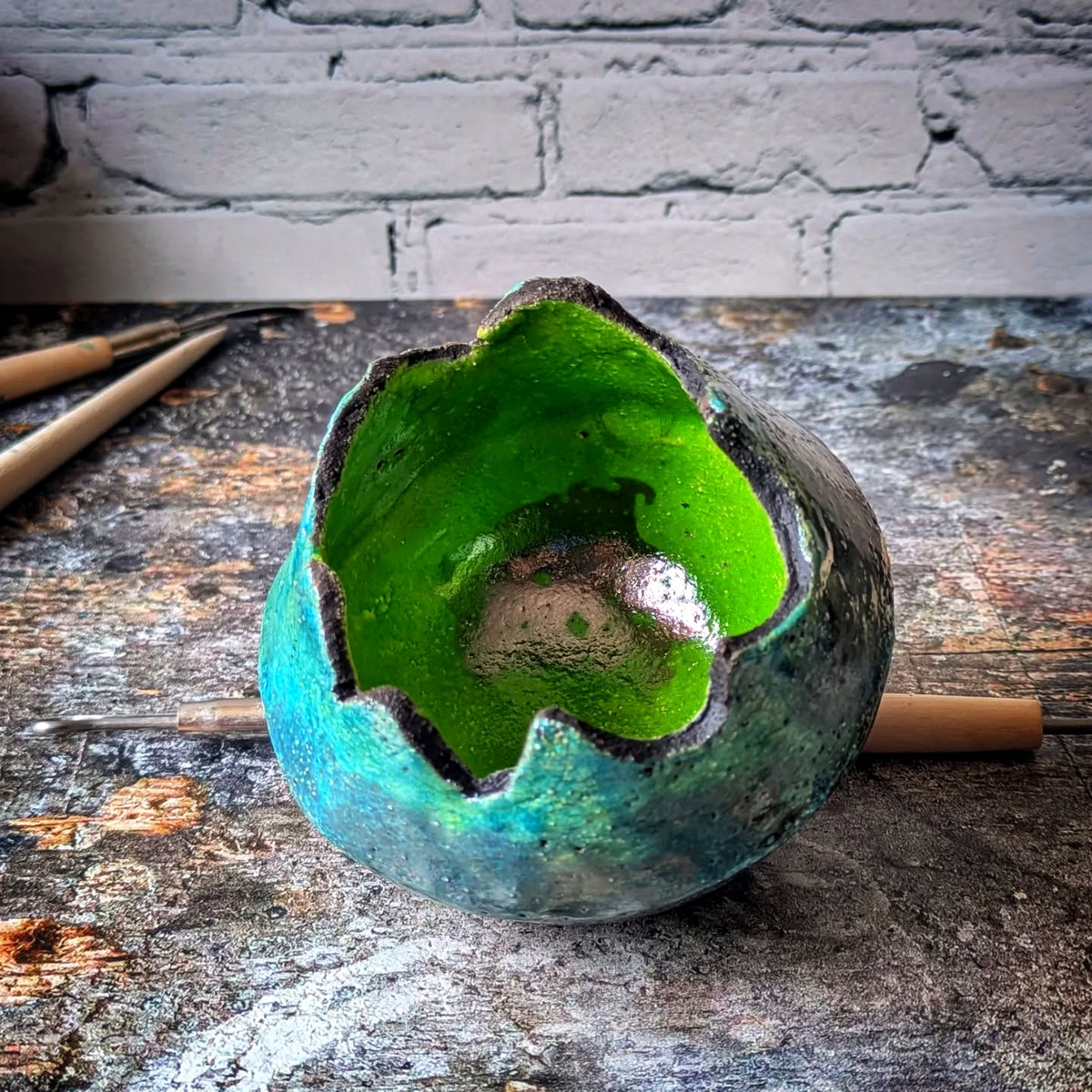 Upper view of the same sculptural vessel, showing its irregular rim and vivid green interior.