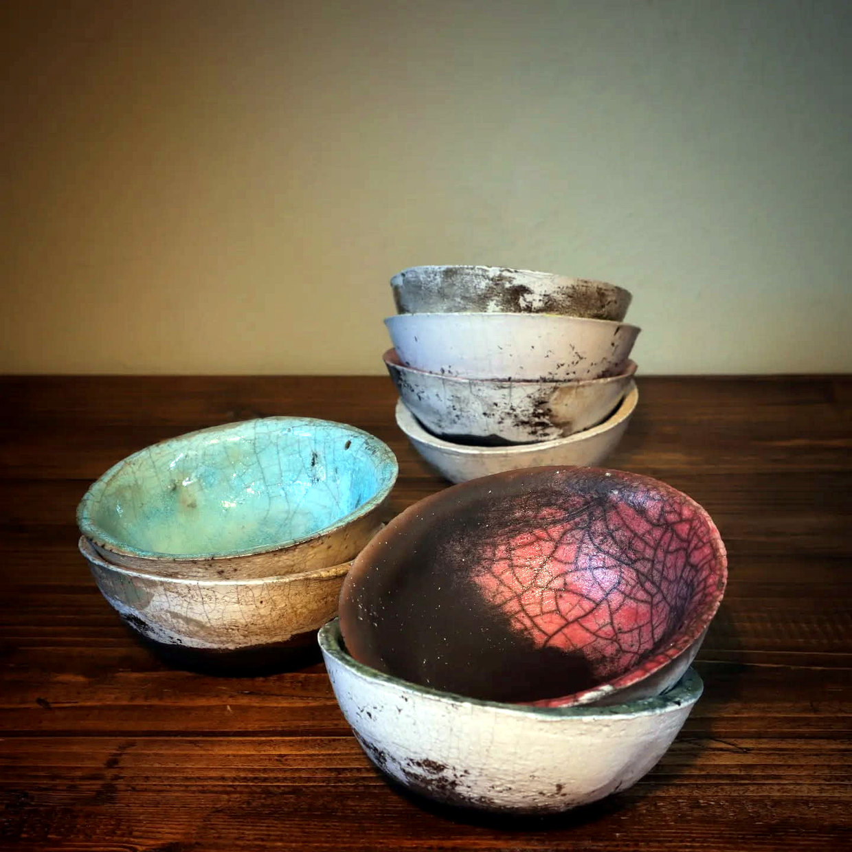 Grouped small ceramic bowls with turquoise and pink crackle-glazed pieces.